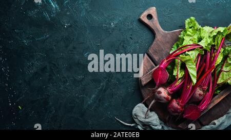 Fresh beetroot with leaves on a black stone background. Healthy food. Top view. Free space for your text. Stock Photo