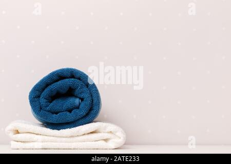Close-up of towels blue and white color lay on a table against the background of light walls. Stock Photo