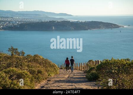 Young couple - man and woman walking on the top of the mountain at San Francisco city, California. Romantic couple walking Stock Photo
