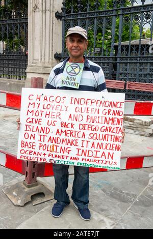 Westminster, London, UK. 9th July, 2019. A man protests outside the House of Commons with a placard saying that America are allegedly squatting on Diego Garcia Island and making it a nuclear base polluting the Indian Ocean and Mauritius. Credit: Maureen McLean/Alamy Stock Photo