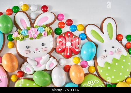 From above view of colorful ginger glazed cookies and chocolate balls isolated on white background. Close up of homemade lovely delicious pastry in shape of easter animals, eggs and carrots. Stock Photo