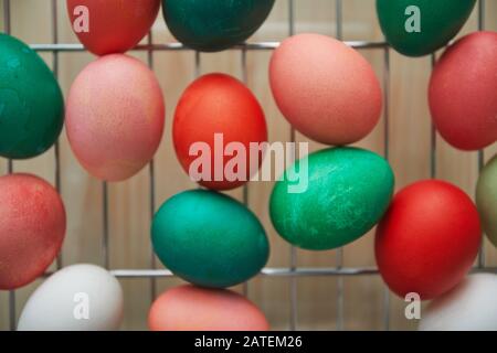 Top view background of red and green hand-painted Easter eggs on drying rack in art studio, copy space Stock Photo