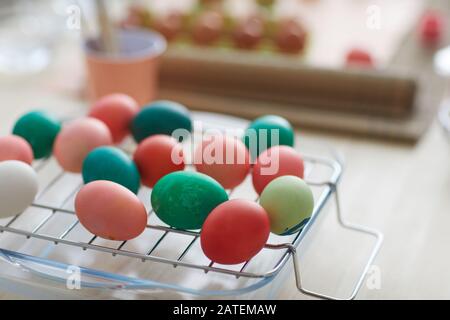 Close up background image of red and green hand-painted Easter eggs on drying rack in art studio, copy space Stock Photo