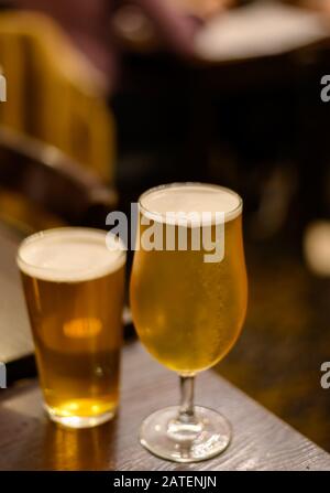 Misty glasses with two pints of cold Scotch ale, pale ale, lager draft beer in English pub close up Stock Photo