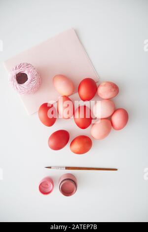 Above view of pastel pink Easter eggs arranged in minimal composition with paint brush on white background, copy space Stock Photo