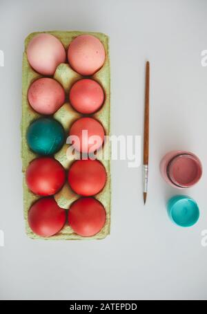 Top view of red Easter eggs in crate with red accent arranged in minimal composition on white background, copy space Stock Photo