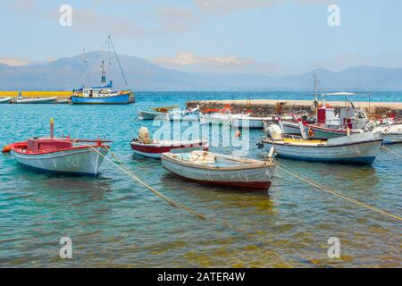 Fishing boats on mountains background. Empty fishing boats near coastline. Seascape with boats on mountain range background. Supply vessel at the central fish market in Euboea, Greece Stock Photo