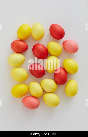 Top view of pastel colored Easter eggs arraigned in minimal composition on white background, copy space Stock Photo