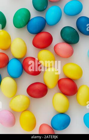 Above view of pastel colored Easter eggs arraigned in minimal composition on white background, copy space Stock Photo