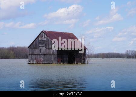 An old barn isolated by a spring flood in Quebec Stock Photo