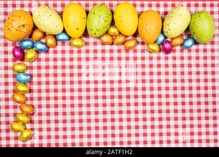 Mix of easter eggs of all colors and sizes on a background of red and ...