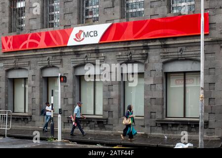 Pedestrians walk past a branch of Mauritius Commercial Bank (MCB) in Port Louis, the capital of Mauritius Stock Photo