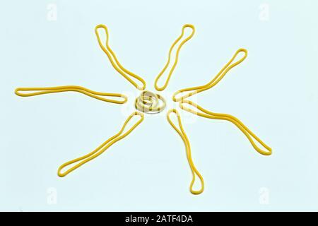 Yellow sun from colored rubber bands on a white background Stock Photo