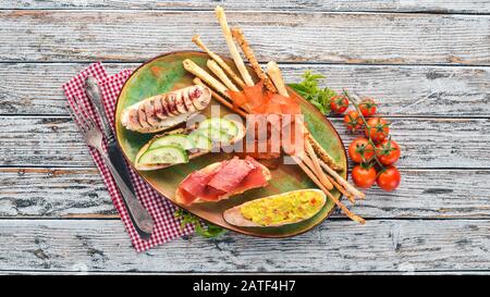 A set of sandwiches with fish, avocados, cucumbers and mushrooms. On a wooden background. Free copy space. Top view. Stock Photo