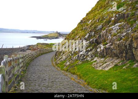 Path leading down from Lindisfarne Castle to Holy Island harbour, Northumberland, UK. Stock Photo