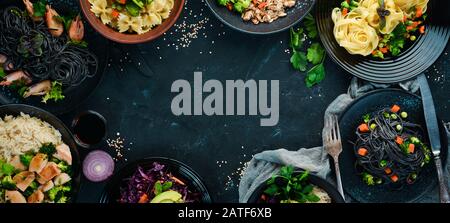 A set of food and dishes. Pasta, rice, risotto, salad. On a black background. Free copy space. Stock Photo