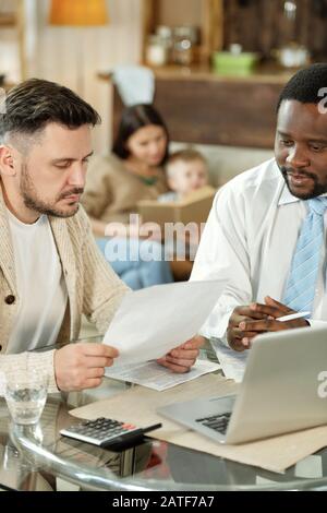 Adult men discussing home loan at table Stock Photo