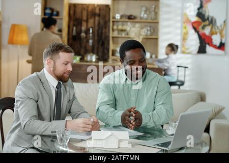 Adviser with cheerful man watching computer Stock Photo