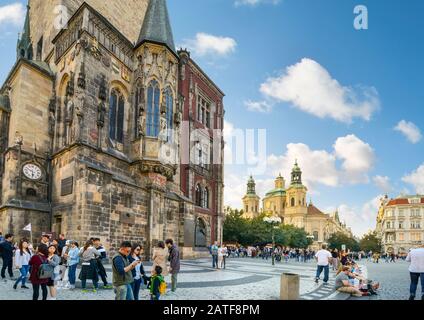 Tourists visit the Astronomical Clock and The Church of Saint Nicholas in Old Town Square in Prague, Czech Republic Stock Photo