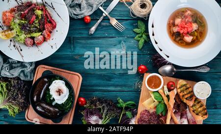 Assortment of healthy food. Cold and hot snacks. On a wooden background. Top view. Copy space. Stock Photo