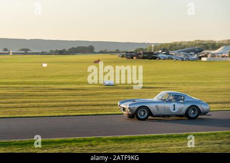 Goodwood Revival and a  Ferrari 250 GT swb Berlinetta hurtling round the Goodwood Motor circuit during the Kinrara Trophy Race. Stock Photo