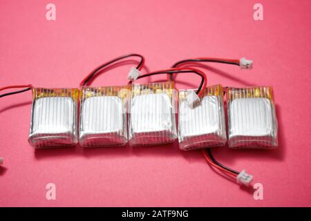 Drone batteries on a pink table. Stock Photo