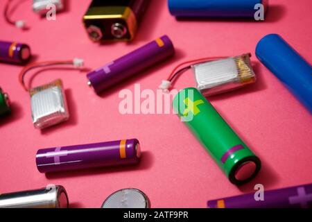 Many batteries on a pink table. Stock Photo