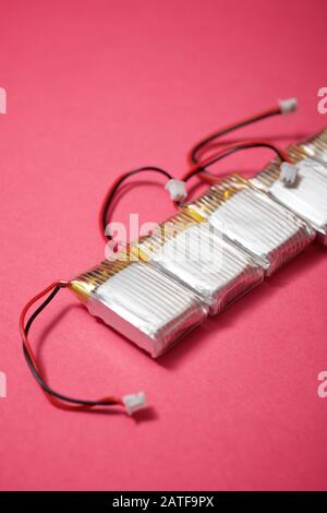 Drone batteries on a pink table. Stock Photo