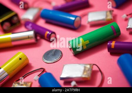 Many batteries on a pink table. Stock Photo