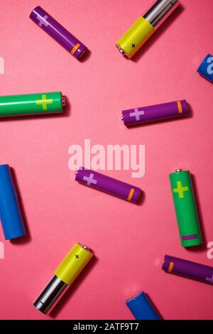 Many batteries on a pink table. Stock Photo