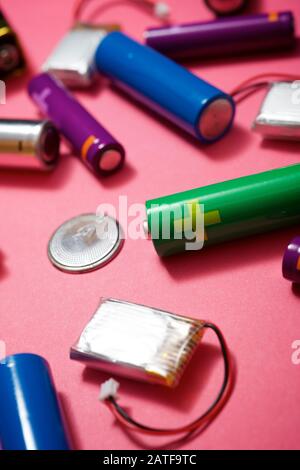 Many batteries on a pink table. Stock Photo