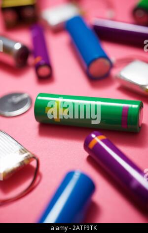 Many batteries on a pink table. Stock Photo