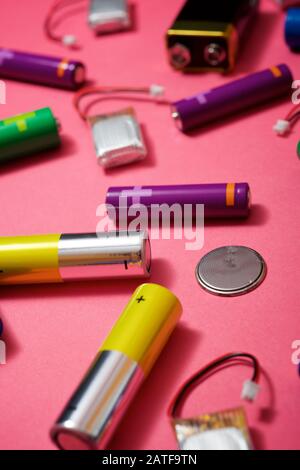 Many batteries on a pink table. Stock Photo