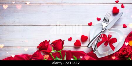 Valentines Day Dinner - Romantic Table Setting With Gift And Roses Stock Photo