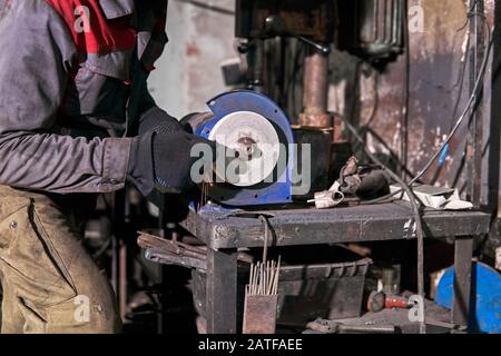 tool sharpening manually on an power grinding wheel Stock Photo