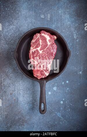 Raw beef steak on pan above Stock Photo