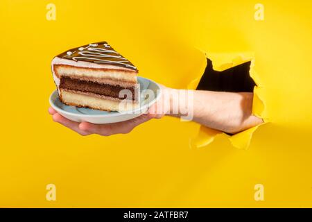 Hand holding a big piece of chocolate cake Stock Photo