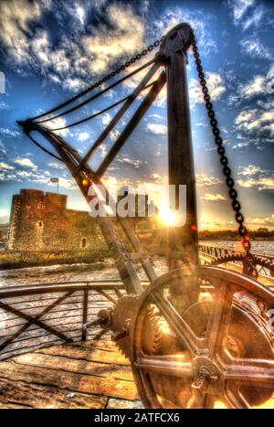 Blackness Castle, Blackness, Scotland. Artistic view of a crane on the 19th century pier, with the historic Blackness Castle in the background. Stock Photo