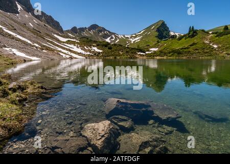 Fantastic hike in the Tannheim Mountains from the summit of Neunerkopfle over Landsberger hut to the beautiful Vilsalpsee. Stock Photo