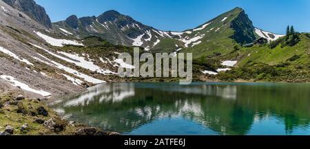 Fantastic hike in the Tannheim Mountains from the summit of Neunerkopfle over Landsberger hut to the beautiful Vilsalpsee. Stock Photo