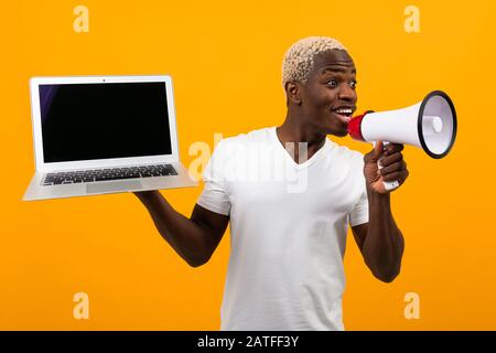 Download African Black Man With Megaphone And Laptop With Mockup On Yellow Studio Background Stock Photo Alamy