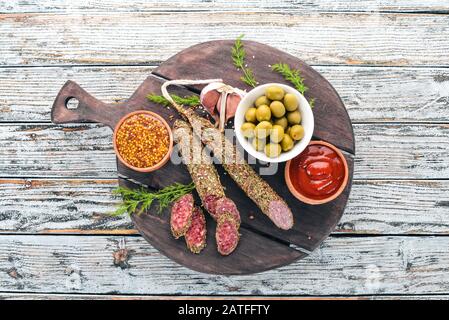 Sausage Fuet. Salami with spices. On a white wooden background. Top view. Free space for your text. Stock Photo