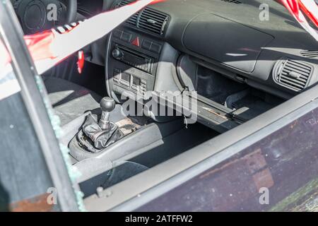 Interior of a burnt out car after a violent accident with police barrier tape in red and white with the German word for police barricade, Germany Stock Photo