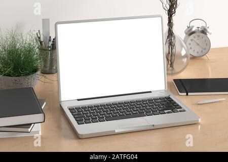 Workspace with blank laptop monitor white screen mock up on the wooden desk near white wall Stock Photo