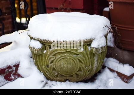 Flower pot covered in a thick layer of clean, white snow on a cold winter's day Stock Photo