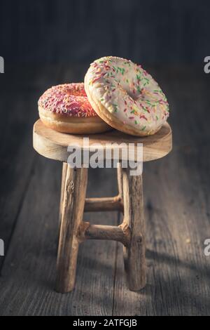 Sweet and tasty donuts on small wooden chair Stock Photo
