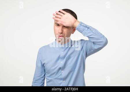Young hispanic man having headache being tired and exhausted. Studio shot Stock Photo