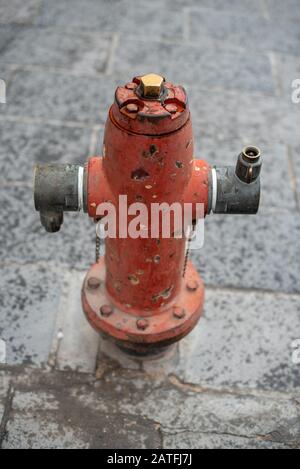 Topdown photo of a typical vintage red fire hydrant standing isolated on an urban street Stock Photo