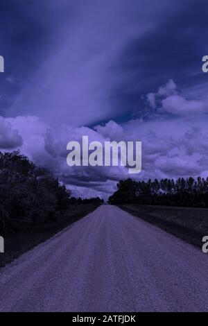 Lonely rural gravel road at night during a full moon Stock Photo