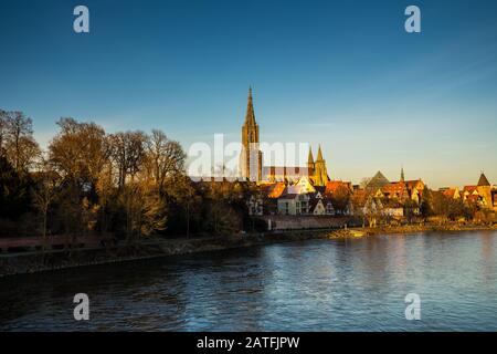 Ulm, Germany, December 29, 2019, Skyline of famous swabian medieval city behind danube river water with impressive ancient minster church building in Stock Photo